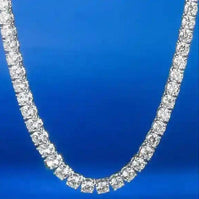 Gold 3 mm CZ Tennis Chain with sparkling cubic zirconia stones on gold-tone brass against blue background