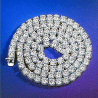Gold 3 mm CZ Tennis Chain with sparkling cubic zirconia stones on gold-tone brass setting coiled on blue background