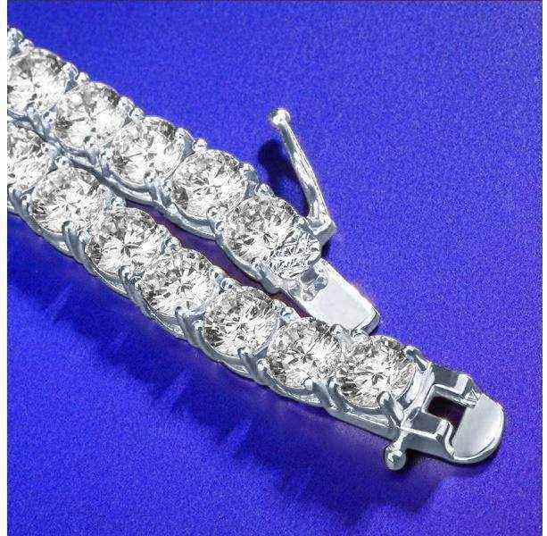Close-up of gold 3 mm CZ tennis chain with sparkling cubic zirconia stones on a blue background