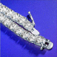 Close-up of gold 3 mm CZ tennis chain with sparkling cubic zirconia stones on a blue background