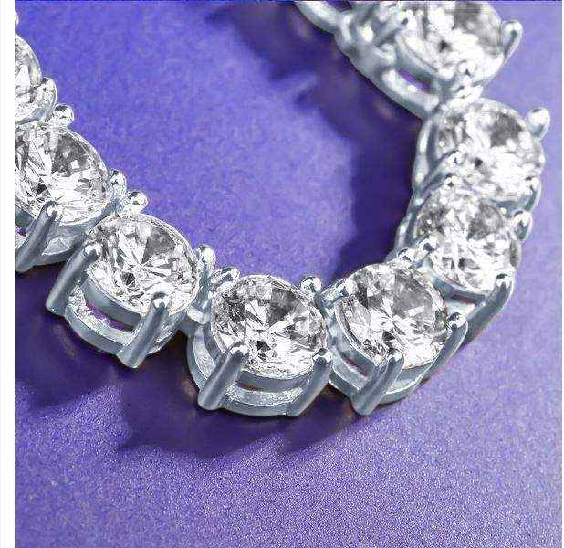 Close-up of gold 3 mm CZ tennis chain with sparkling cubic zirconia stones on purple background