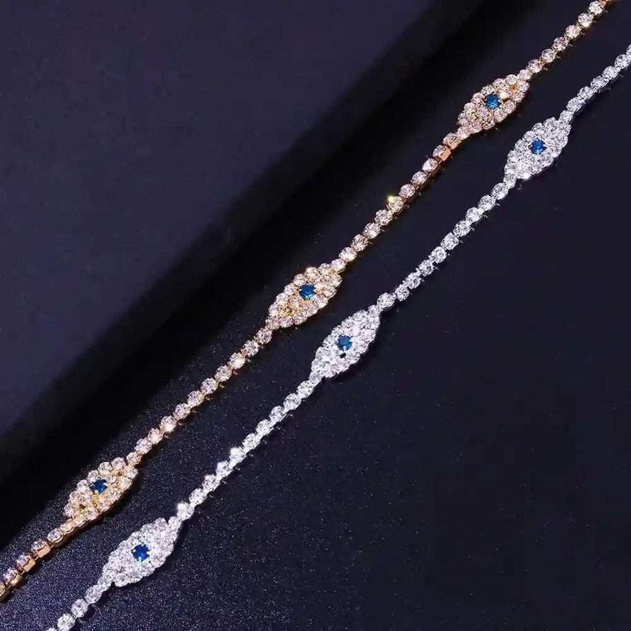 Two vintage evil eye crystal anklets with cubic zirconia stones in silver and gold finishes on black background