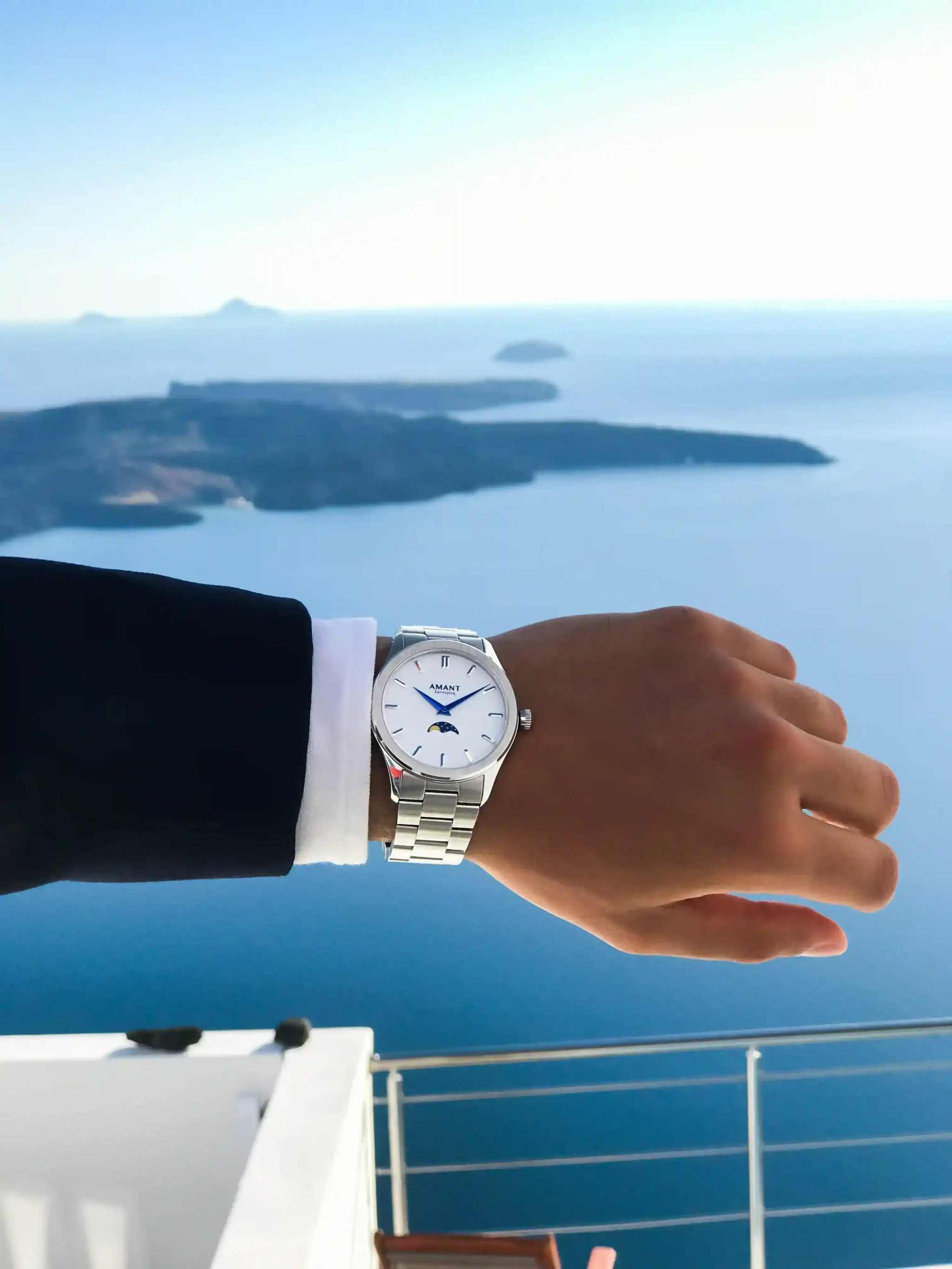 Santorini Moonphase Watch on wrist showing moonphase dial, stainless steel band, overlooking sea view