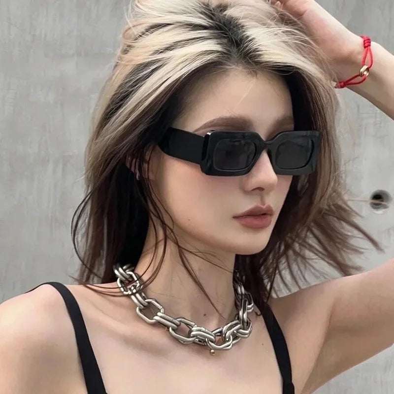 Woman wearing black vintage rectangle sunglasses with polycarbonate frame and UV400 resin lenses