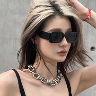 Woman wearing black vintage rectangle sunglasses with polycarbonate frame and UV400 resin lenses