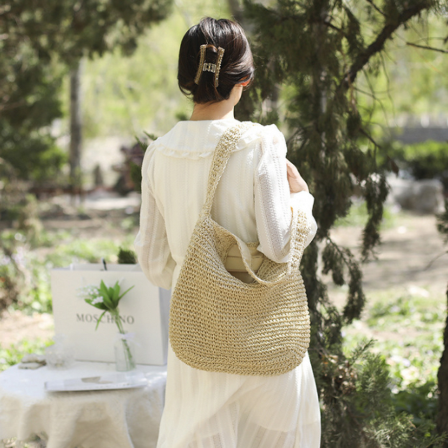 woman wearing white dress carrying casual summer shoulder beach bag woven straw large capacity outdoors