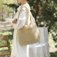 Casual summer shoulder beach bag made of straw with bohemian style and roomy interior, perfect for beach essentials.