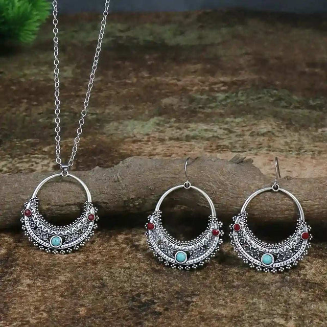 Rustic Tribal Stone Set with turquoise and red bead detailed silver necklace and matching hoop earrings on natural wood background
