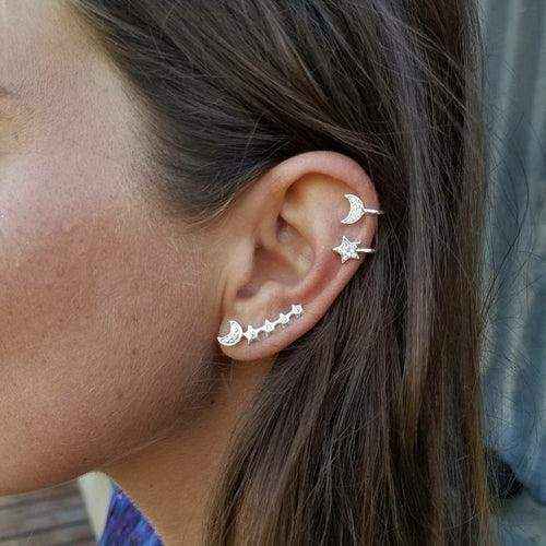 Close-up of ear wearing a Moon - Star Earring and cuff set with gold-tone celestial designs and crystal accents.