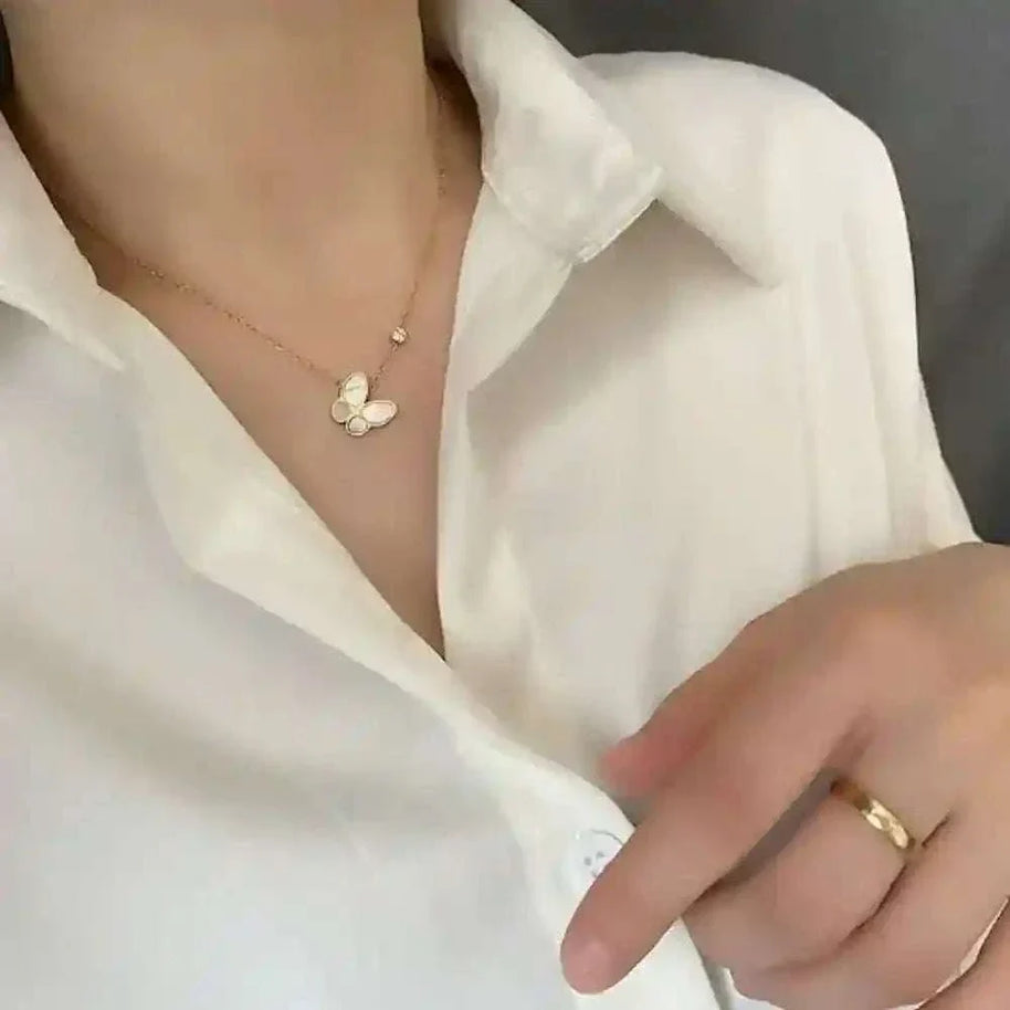 Butterfly Mother-of-Pearl Necklace with gold-plated chain on a woman wearing a white blouse