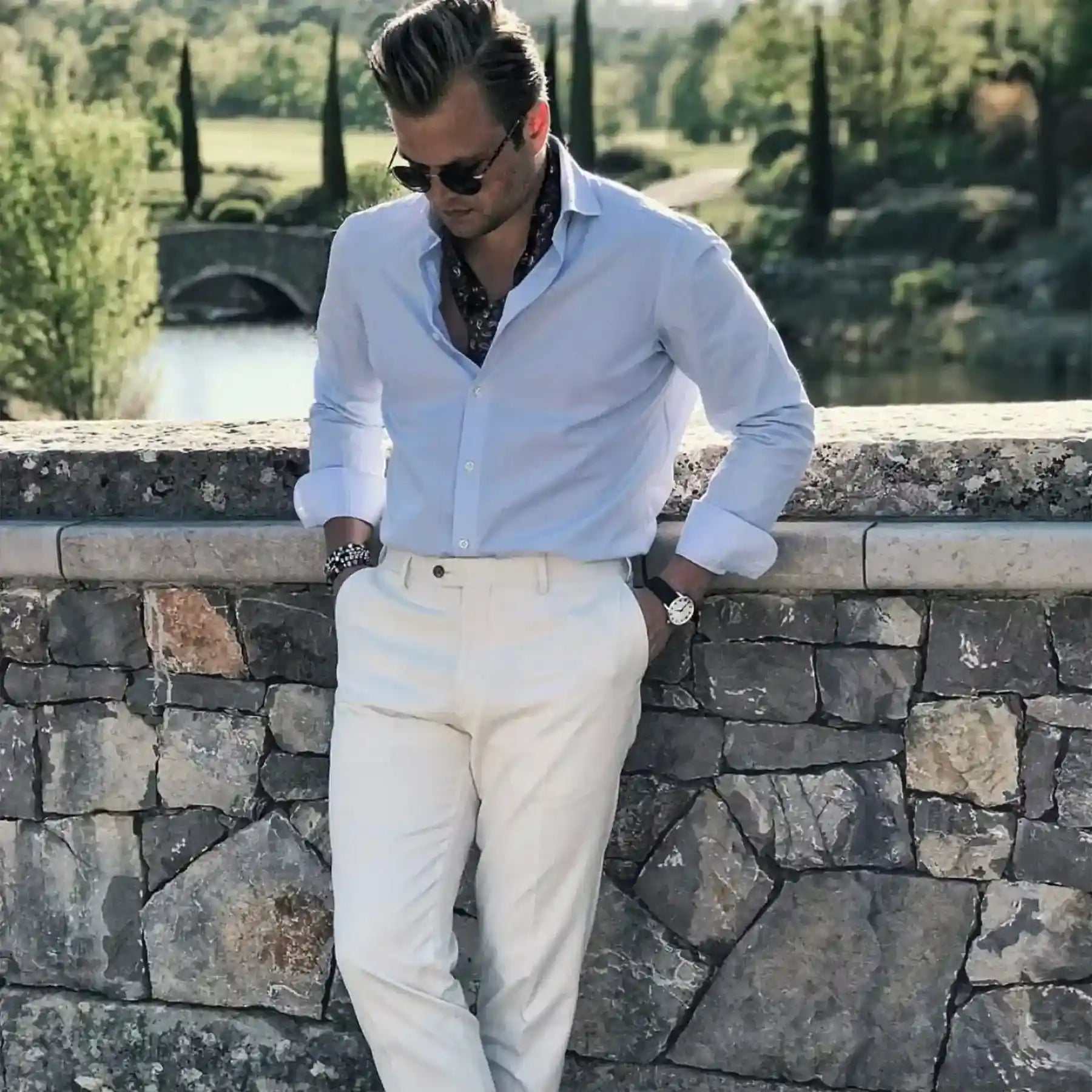Man wearing London Ultra-Thin Watch with surgical-grade steel case and Italian calfskin strap outdoors by stone wall