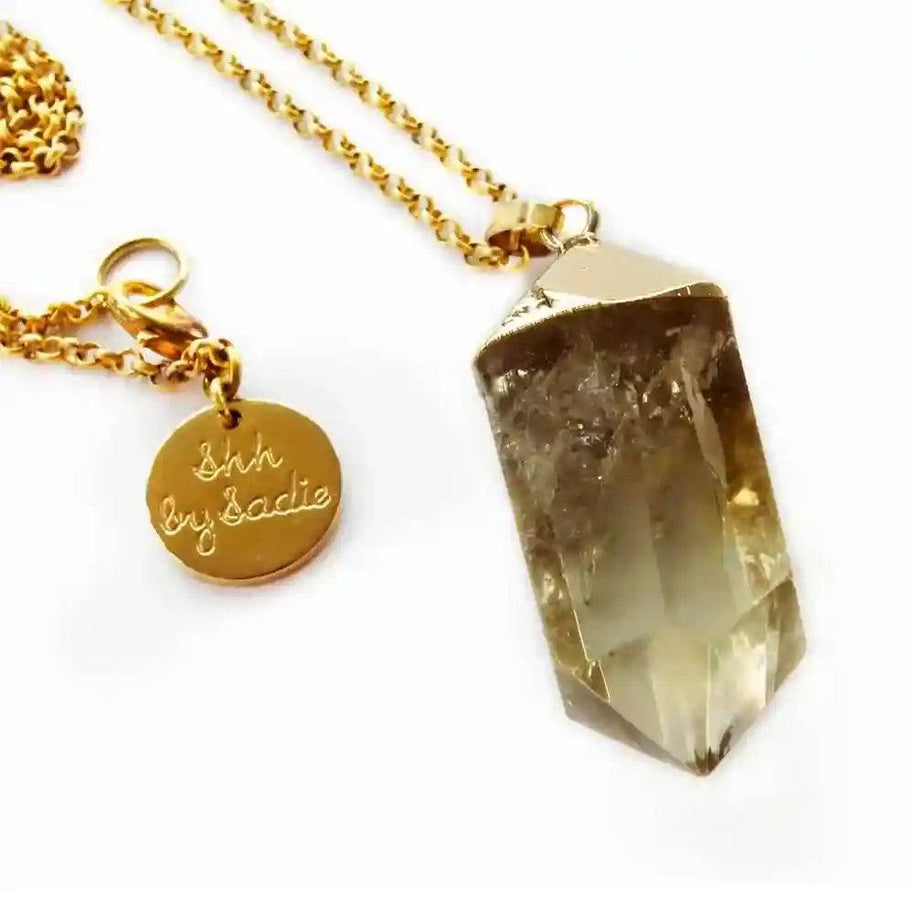 Gold-plated Glow Crystal Quartz Necklace with genuine quartz pendant and "Shh by Sadie" tag