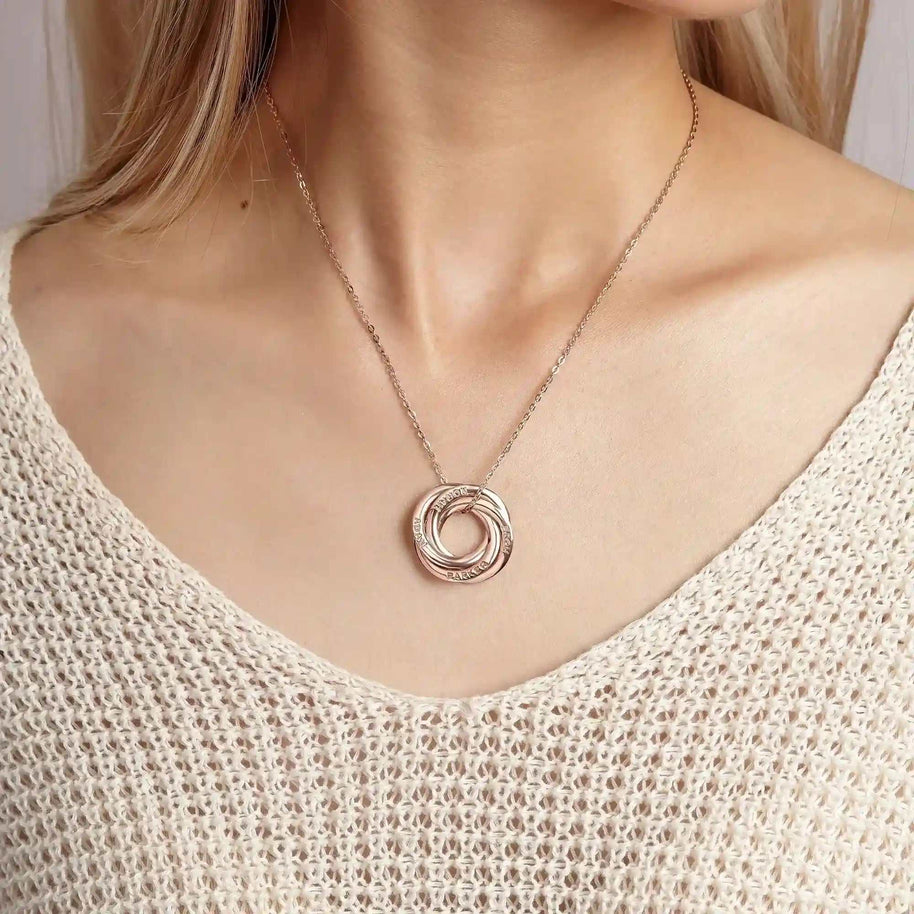 Woman wearing interlocking name ring necklace in silver with customizable engraved rings on a delicate chain
