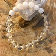 Rainbow Moonstone Stretch Bracelet with clear crystal quartz beads on stretch cord displayed on wooden surface