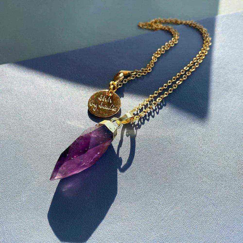 Glow Crystal Quartz Necklace with gold-plated amethyst pendant and signature tag on a delicate chain
