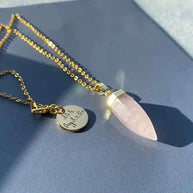 Gold-plated Glow Crystal Quartz Necklace with rose quartz pendant and signature Shh by Sadie tag on chain