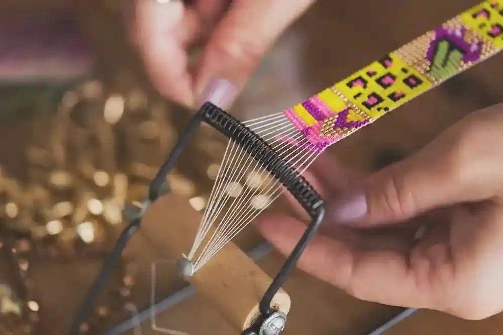 Close-up of hands weaving colorful bead-loom strap for St. Tropez Blue Quartz Necklace artisan craftsmanship
