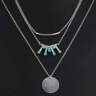 Turquoise layered necklace with silver chains and turquoise beads on black background