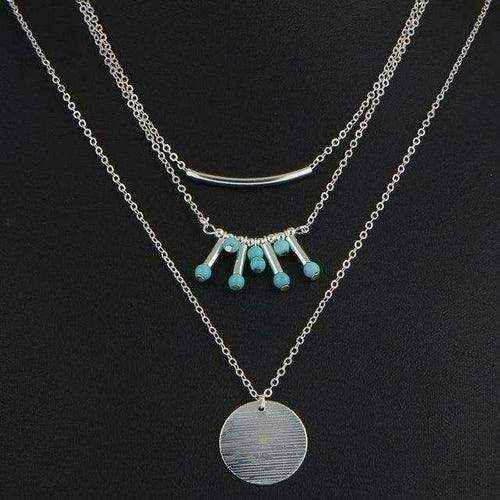 Turquoise layered necklace with silver chains and genuine turquoise beads on black background