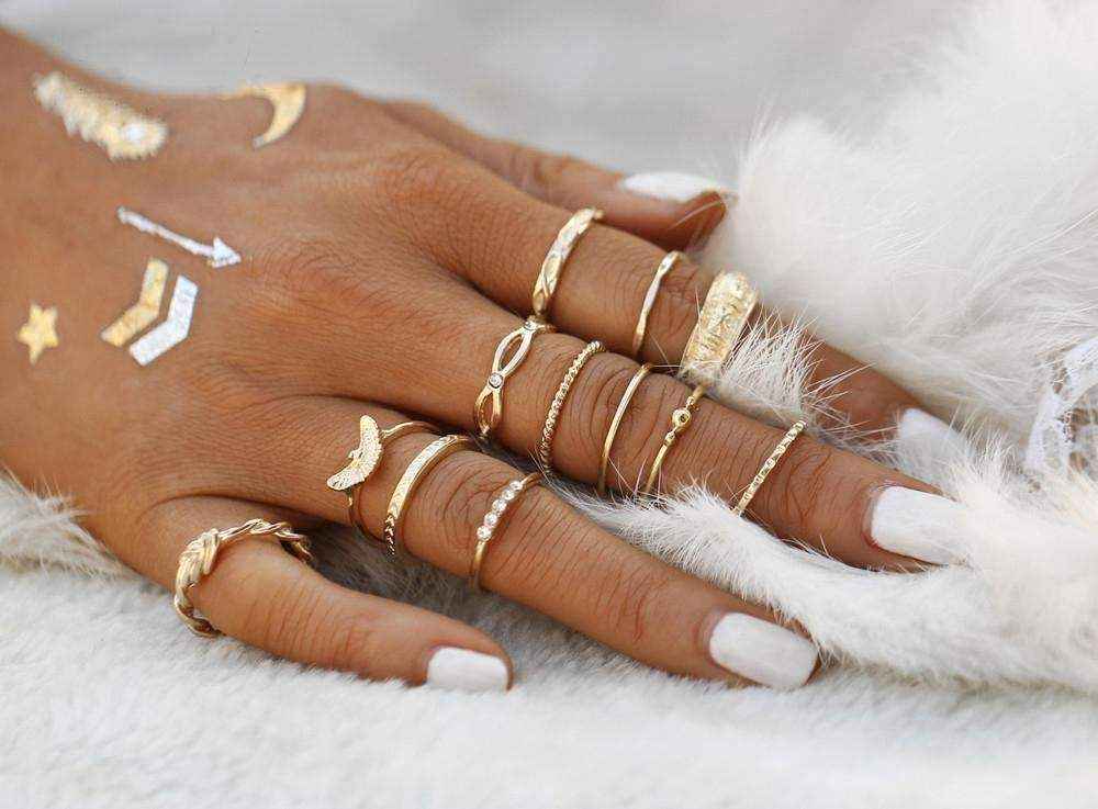 Golden Gem stackable rings on hand with white nail polish and delicate gold designs