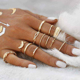 Golden Gem stackable rings on hand with white nail polish and delicate gold designs