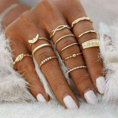 Close-up of hand wearing multiple Gold Gem Stackable Rings with varied designs and stone accents on fingers