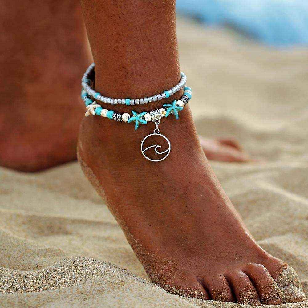 Ocean Double Layer Anklet with turquoise beads and ocean wave charm on sandy beach foot