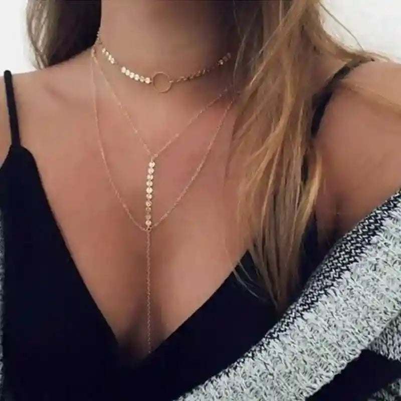 Woman wearing three-layer lariat choker necklace with delicate chains and circle pendant