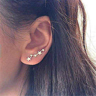 Close-up of ear wearing elegant Star Ear Crawlers with a delicate climbing star design in silver finish